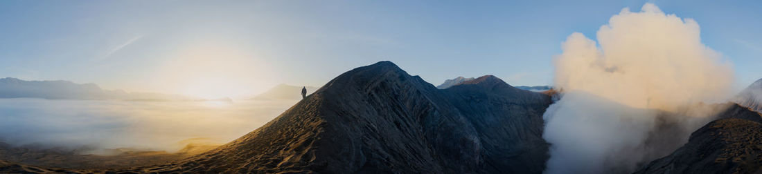 Panoramic view of land and mountains against sky during sunset