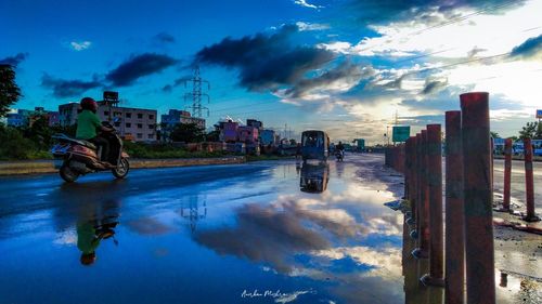 Reflection of people on puddle in city