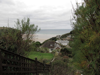 Scenic view of sea by buildings against sky