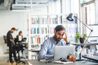 Full length of man using mobile phone while sitting on table