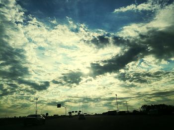 Silhouette of cars on road against sky