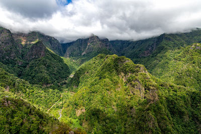 Scenic view of green mountains against sky