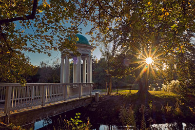 Built structure by trees against sky during autumn