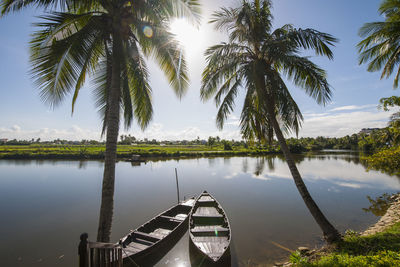 Two rowing boats parked at calm river close to hoi an