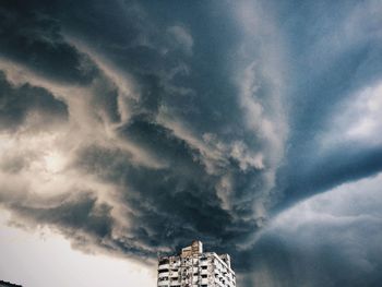 Low angle view of storm clouds over building