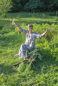 Portrait of young woman sitting on field