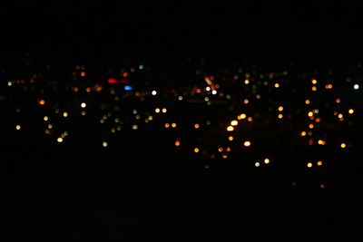 Illuminated city against sky at night