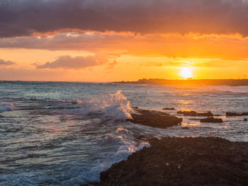 View of sea against cloudy sky during sunset