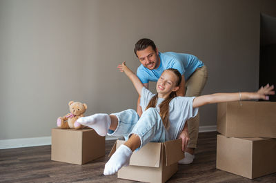 Side view of mother and daughter sitting on sofa at home