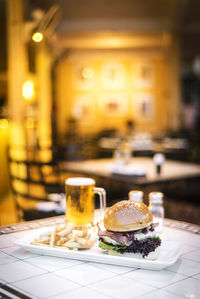 Close-up of fresh meal and beer on table in restaurant