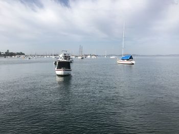 Boats sailing in sea against sky