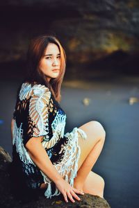 Young woman looking away while sitting in water