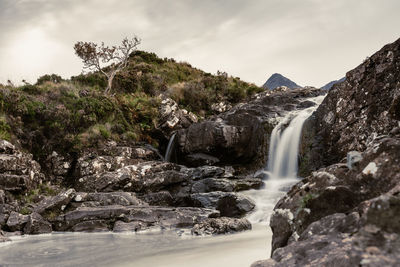 Scenic view of waterfall against sky