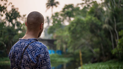 Rear view of man against trees