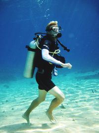 Full length of mid adult man scuba diving undersea