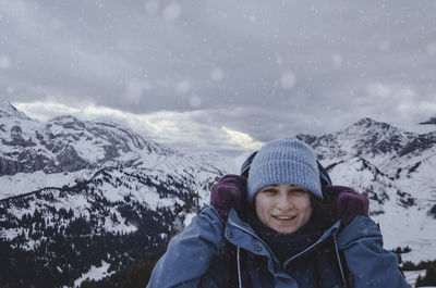 Portrait of smiling woman on snowcapped mountain