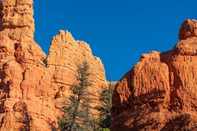 Low angle landscape from red canyon of orange hoodoos and spires or rock formations against sky