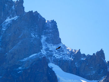 Low angle view of mountains against clear sky during winter