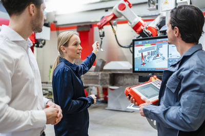 Mature engineer explaining colleagues in meeting at industry