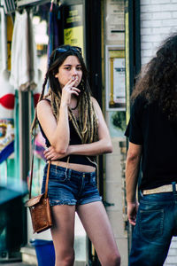 Full length of woman standing against graffiti