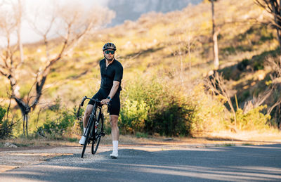 Rear view of man riding bicycle on road