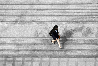 High angle view of young woman with umbrella on steps