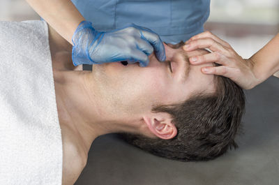 Midsection of woman giving massage to man in beauty spa