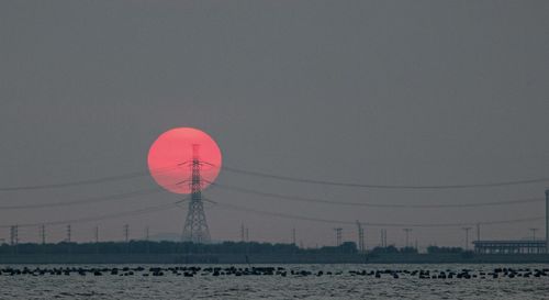 Red umbrella on land against clear sky during sunset