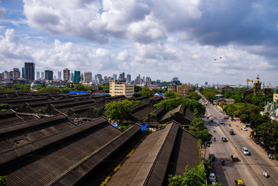 High angle view of railroad tracks by buildings in city against sky