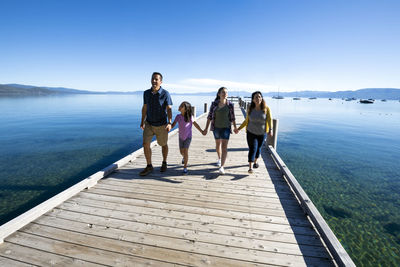 A family walks on a pier on a beautiful day in south lake tahoe, ca