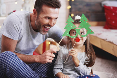 Happy father and daughter with props at home during christmas