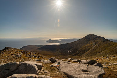 Scenic view of island mountain against sky near sea