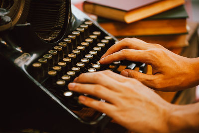 Cropped hands of man using typewriter