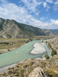 Scenic view of river amidst mountains against sky