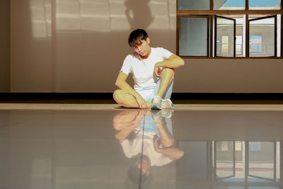 Full length of young woman standing by window