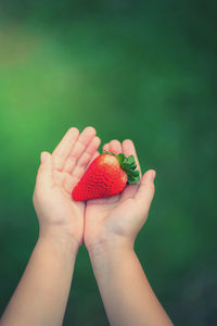 Close-up of hand holding strawberry