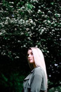 Portrait of woman standing against plants