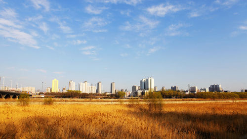 View of cityscape against cloudy sky