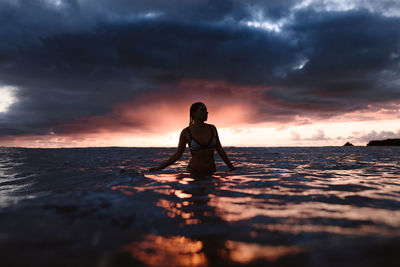 Man standing on beach against sky during sunset