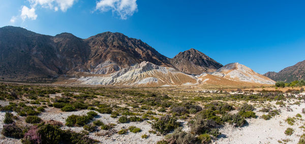 Panoramic view of landscape and mountains against blue sky