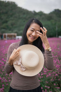 Side view of young woman wearing hat standing outdoors