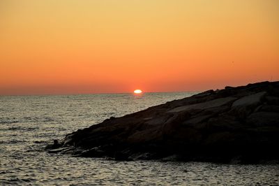 Scenic view of sea against orange sky