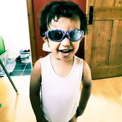 Portrait of smiling boy standing on floor at home