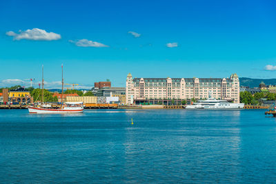 Buildings by sea against sky