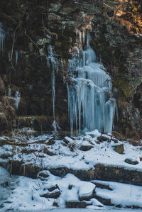 Scenic view of waterfall in forest during winter