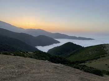 Scenic view of sea and mountains against sky during sunset