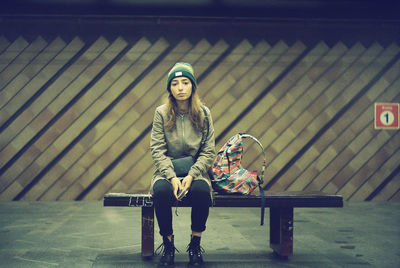 Portrait of young woman sitting on bench