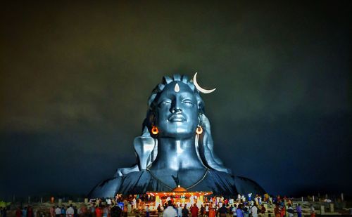 Statue of illuminated building against sky