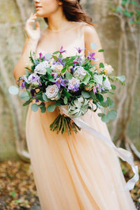 Midsection of woman holding flower bouquet