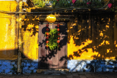 Traditional yellow colored house with a lantern over a door in hoi an ancient town, vietnam